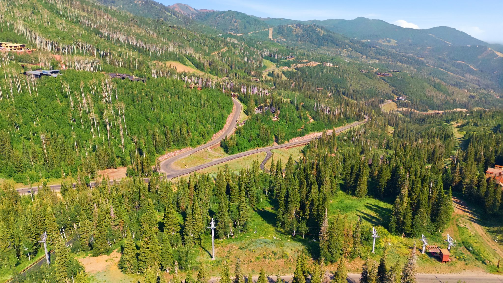 Expansive mountain landscape featuring dense evergreen and deciduous forests
