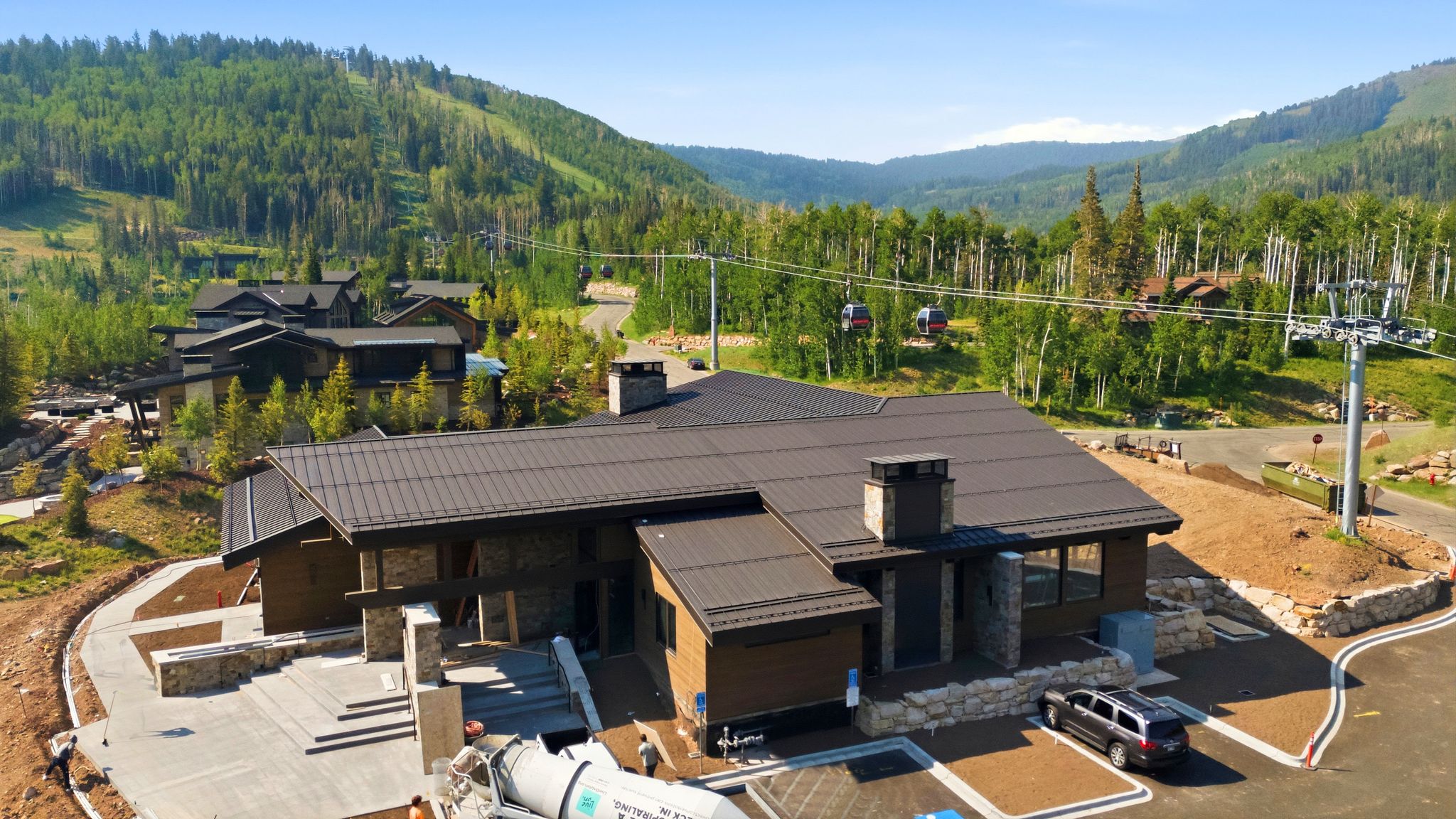Contemporary mountain residence featuring a dark metal roof, stone accents, and expansive window placements