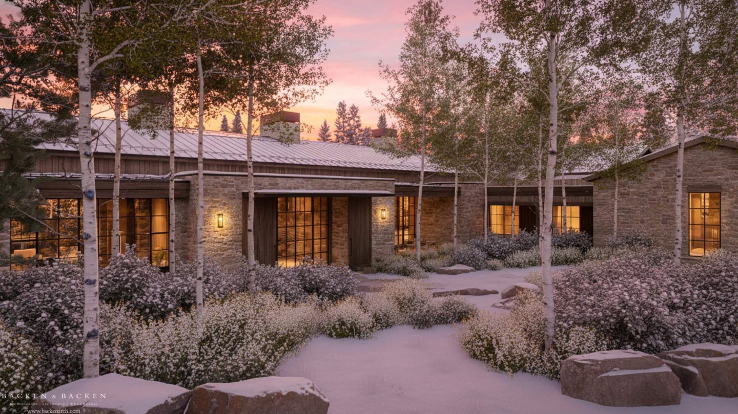 Back of property at dusk with stone siding and a metal roof