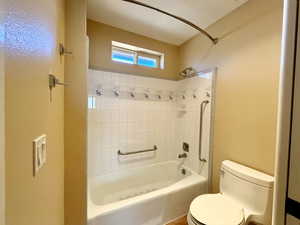 Primary bedroom's full bathroom featuring shower / bath combination and toilet privately enclosed