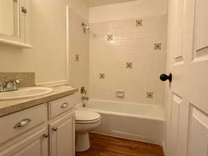 Bathroom with vanity, shower / washtub combination, and dark wood-type flooring