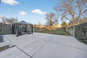 Fenced backyard featuring a gazebo, a patio area, and an outdoor living space