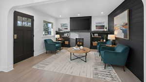 Sitting room featuring wood finished floors, recessed lighting, a fireplace, arched walkways, and wood walls