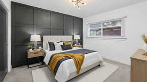 Bedroom with a decorative wall, light colored carpet, and a chandelier