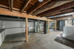 Unfinished below grade area with washer / dryer and heating unit