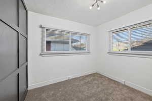 Unfurnished bedroom with carpet floors and a textured ceiling