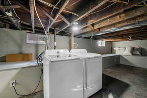 Laundry area with unfinished concrete flooring and separate washer and dryer