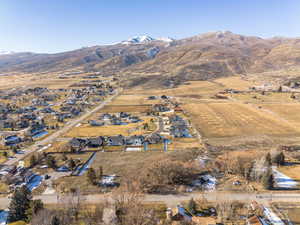 Aerial view of property and surrounding area with mountains and nearby suburban area