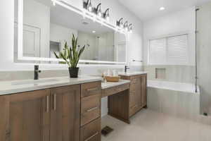 Bathroom with double vanity, a shower stall, a bath, and recessed lighting