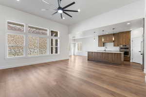 Unfurnished living room featuring dark wood-style flooring, a ceiling fan, and recessed lighting