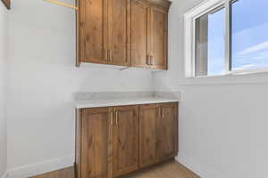 Bar featuring light stone countertops and brown cabinets