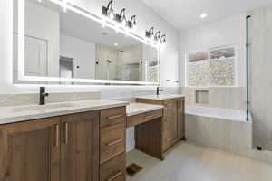 Full bathroom featuring a stall shower, double vanity, a bath, recessed lighting, and light flooring