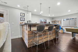 Indoor dry bar with dark countertops, plenty of natural light, billiards, dark wood-type flooring, and recessed lighting