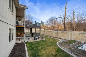 Fenced backyard featuring a patio area, a garden, and a wooden deck