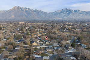 Aerial view of property and surrounding area featuring nearby suburban area and mountains