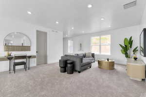 Living room with light carpet and recessed lighting