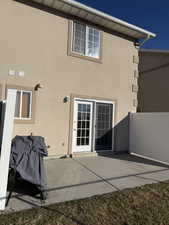 Back of house featuring stucco siding and a patio