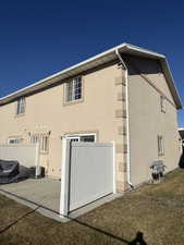 View of side of property with stucco siding and a patio
