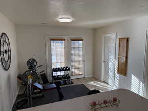 Workout area featuring a textured ceiling and light tile patterned flooring