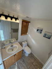 Half bath with vanity and a textured ceiling