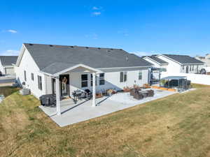 Back of property featuring a patio, a shingled roof, an outdoor living space, and a residential view
