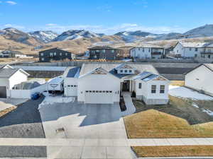 View of front of house with a mountain view, a garage, concrete driveway, a residential view, and board and batten siding