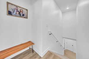 Staircase featuring wood finished floors and recessed lighting