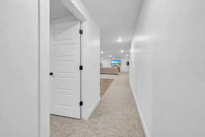 Hall featuring light colored carpet and recessed lighting