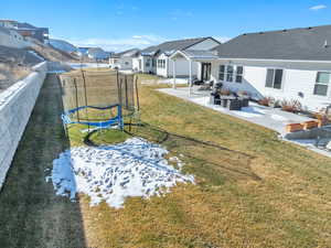 View of yard with a trampoline, a patio area, a residential view, and an outdoor living space