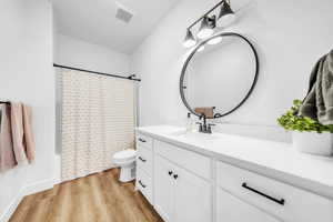 Bathroom with shower / tub combo, vanity, and light wood-type flooring