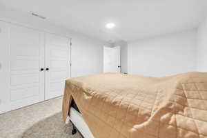 Carpeted bedroom featuring a closet