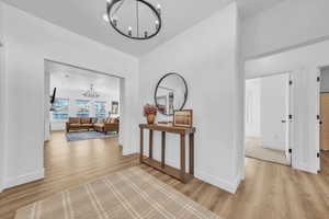 Hall featuring a chandelier and light wood-type flooring