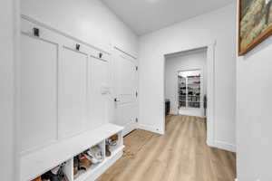 Mudroom with light wood-type flooring and baseboards