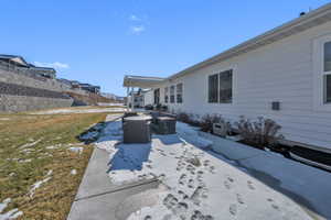Snow covered property featuring outdoor lounge area, a patio area, and a lawn