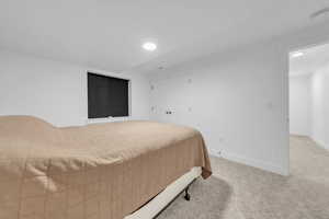 Bedroom featuring baseboards and light carpet