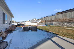 Snow covered patio with a patio area, a fenced backyard, and a trampoline