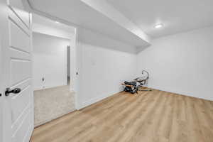 Finished basement with baseboards and light wood-style flooring
