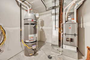 Utility room featuring water heater and heating unit