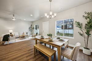 Dining room with dark wood-type flooring, ceiling fan, and a chandelier