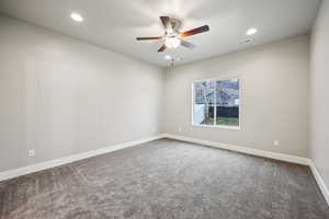 Carpeted spare room featuring a ceiling fan and recessed lighting