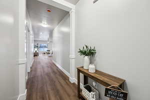 Corridor with baseboards and dark wood-style floors