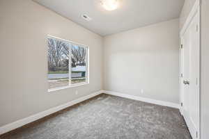 Carpeted empty room featuring baseboards