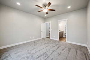 Unfurnished bedroom with recessed lighting, ceiling fan, light carpet, and ensuite bath