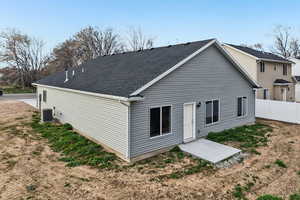 Rear view of house with a patio and a shingled roof