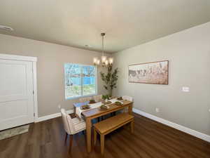 Dining space featuring dark wood finished floors and hanging lights