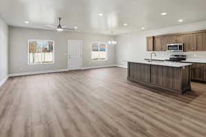 Kitchen featuring open floor plan, an island with sink, recessed lighting, stainless steel appliances, and pendant lighting