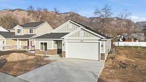 Craftsman house featuring board and batten siding, a porch, stone siding, driveway, and a mountain view