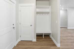 Mudroom with light wood finished floors and recessed lighting