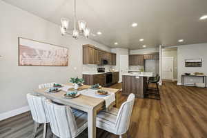 Dining room featuring dark wood-style flooring and suspended lighting