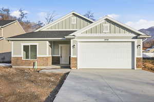 Craftsman house with board and batten siding, concrete driveway, an attached garage, and a shingled roof